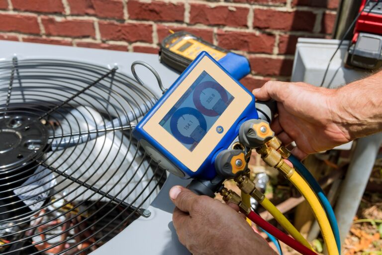 Close up view of an HVAC technician performing maintenance on an outdoor AC unit.