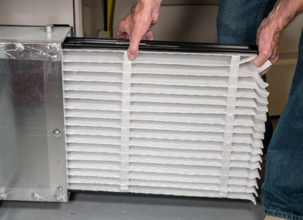 Close up view of replacing an air filter in a furnace unit.